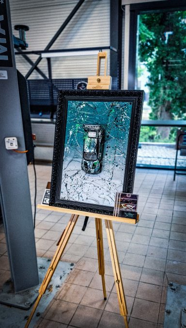 Ein Handy in einem gerahmten Kunstwerk auf einer Staffelei.